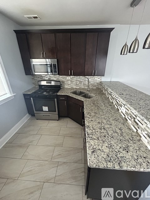 A kitchen with granite countertops and a stove top oven.