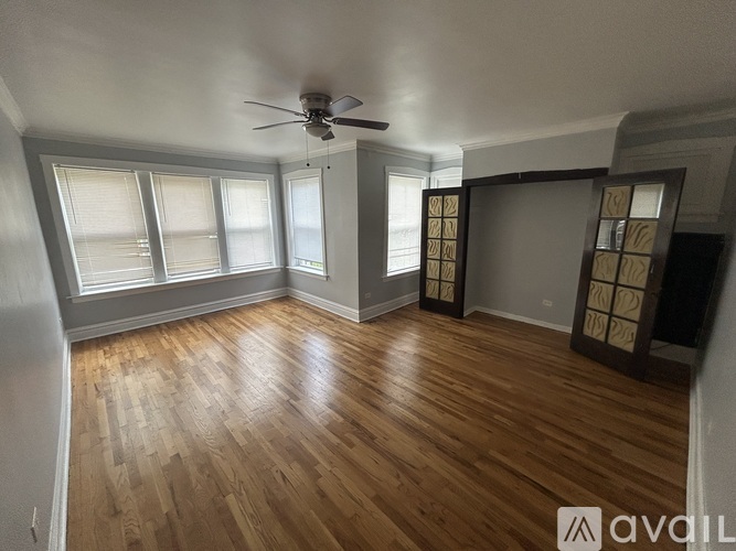 A room with wooden flooring and a ceiling fan.