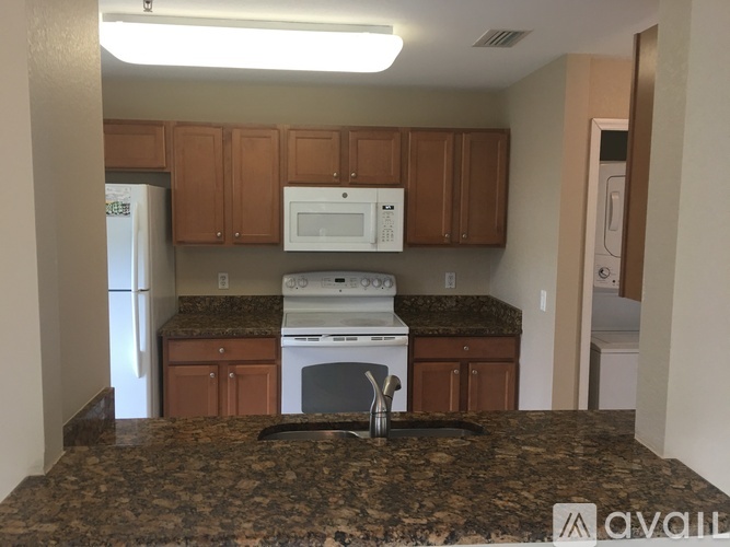 A kitchen with brown cabinets and a granite countertop.