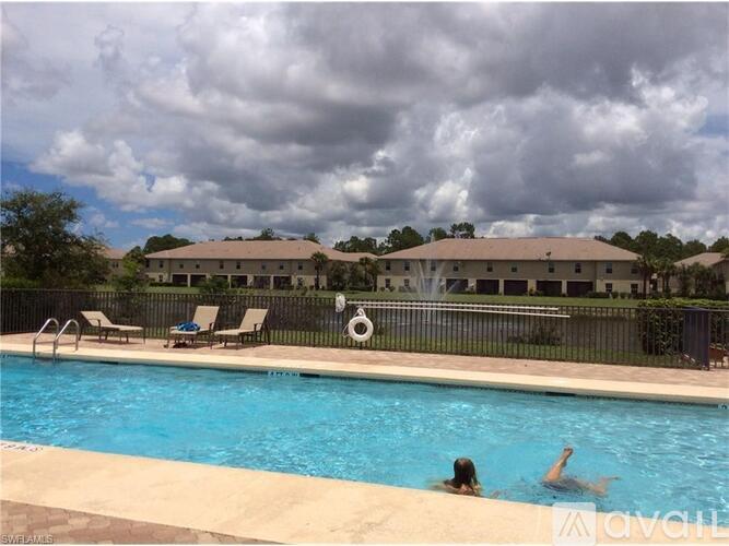 A swimming pool with people in it and a building in the background.