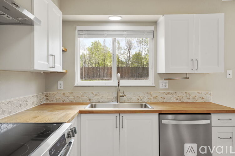 A kitchen with white cabinets and a wooden countertop.