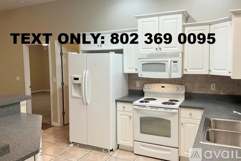 A kitchen with white appliances and cabinets is on the market.