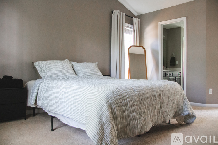 A bedroom with a large bed and a dresser.