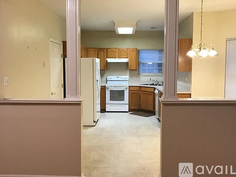 A kitchen with wooden cabinets and a white stove top oven.
