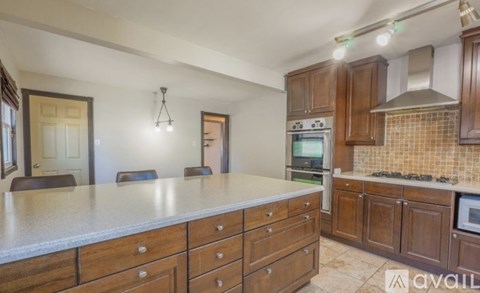 A kitchen with wooden cabinets and a granite countertop.