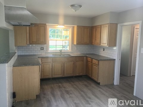 A kitchen with wooden cabinets and a window.