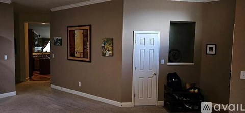 A living room with a white door and a painting on the wall.