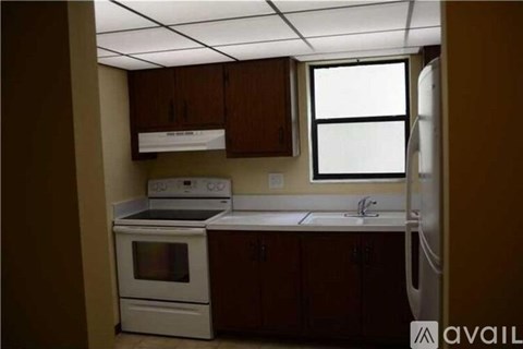A kitchen with white appliances and brown cabinets.