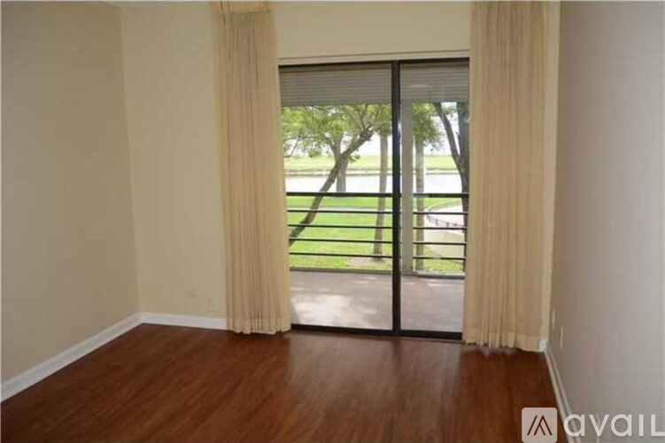 A room with a sliding glass door leading to a balcony.