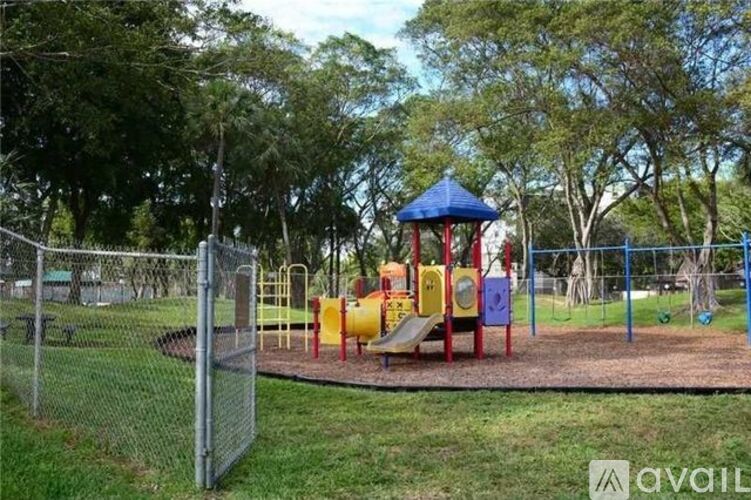 A playground with a blue and yellow slide and a red and yellow swing set.