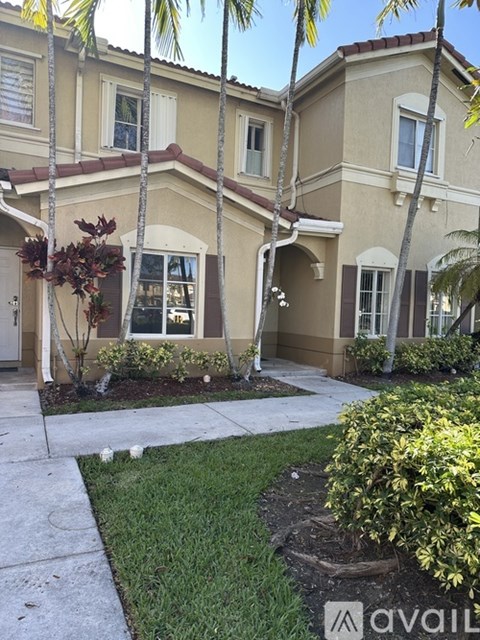 A beige house with a brown roof and a white door.