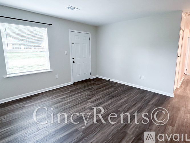 A room with a white door and a window with blinds.