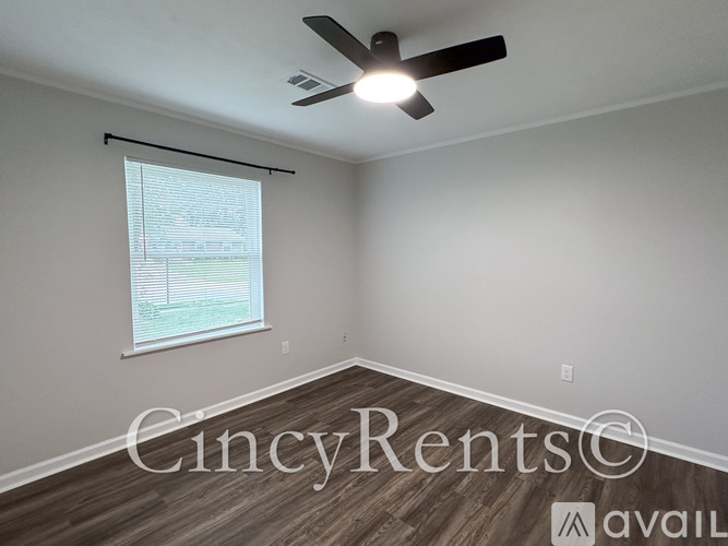 A room with a ceiling fan and a window with blinds.