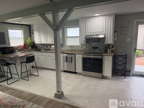 A kitchen with white cabinets and a large island.