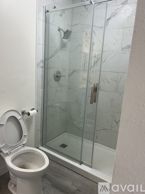 A white toilet is next to a glass shower door.