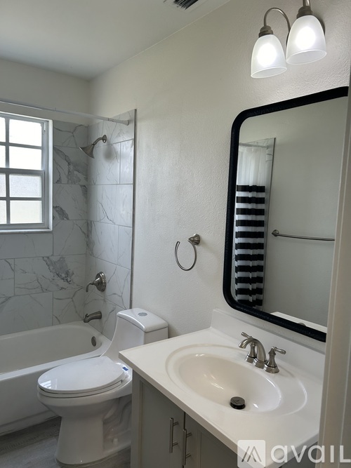 A white toilet sits next to a white sink in a bathroom.