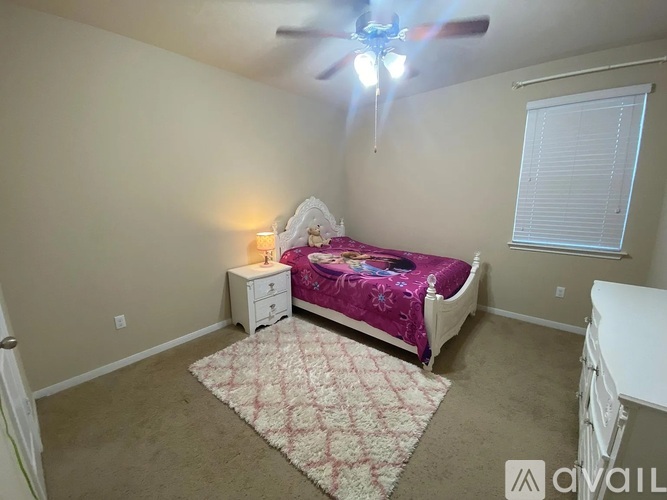 A bedroom with a bed, dresser, and ceiling fan.
