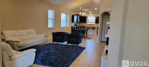 A living room with a white couch and a black chair.