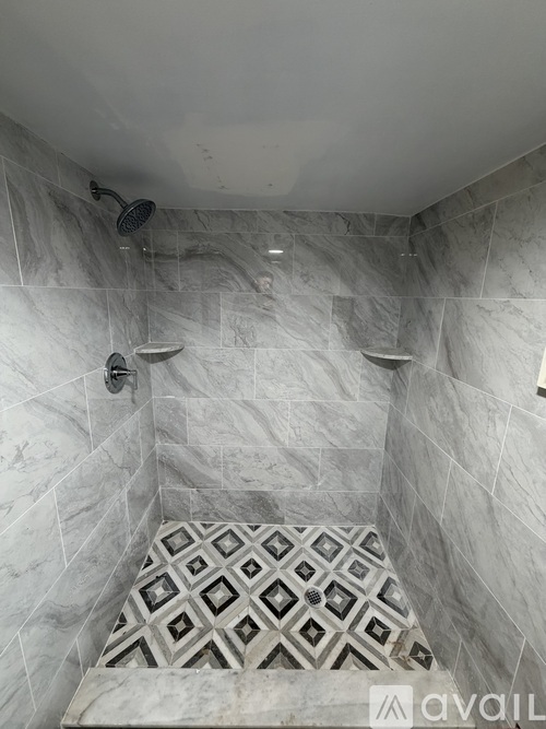A bathroom with a tiled shower and floor.
