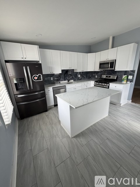 A modern kitchen with white cabinets and a central island.