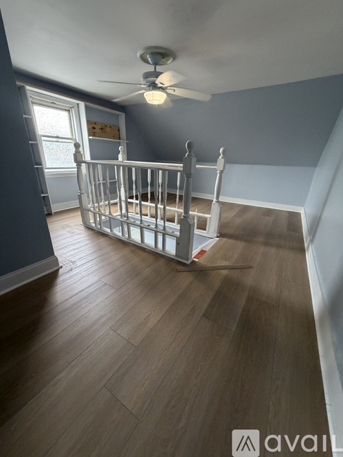 A baby's room with a crib and a ceiling fan.