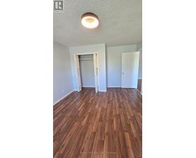 A room with wood flooring and a ceiling light.