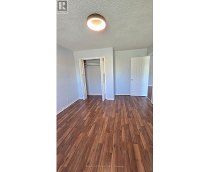 A room with wood flooring and a ceiling light.