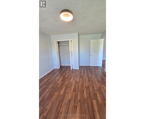 A room with wood flooring and a ceiling light.