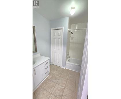 A white bathroom with a door and a shower.