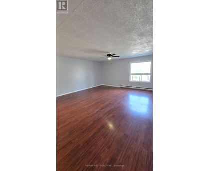 A room with a wooden floor and a ceiling fan.