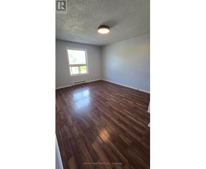 A room with wooden flooring and a window.