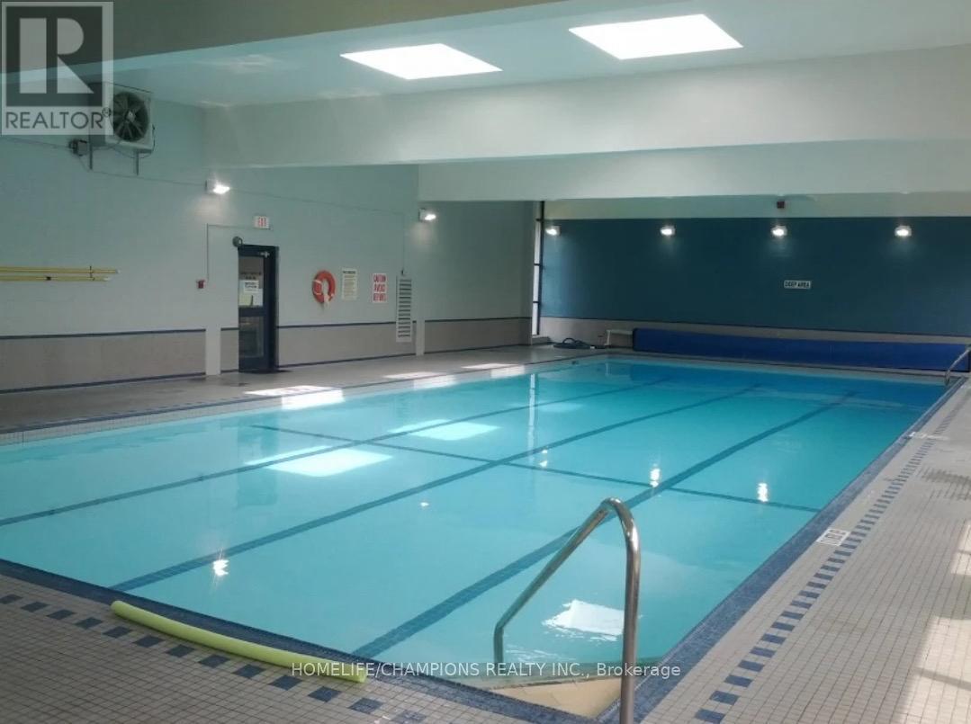 A large indoor swimming pool with a blue bottom and white walls.