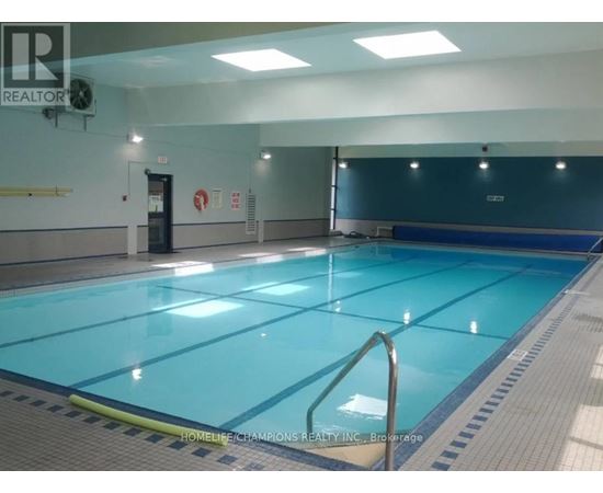 A large indoor swimming pool with a blue bottom and white walls.