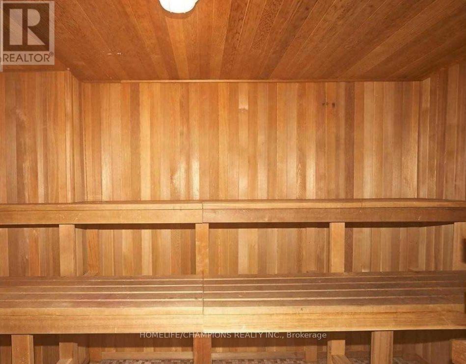 A wooden sauna with a bench and a light on the ceiling.