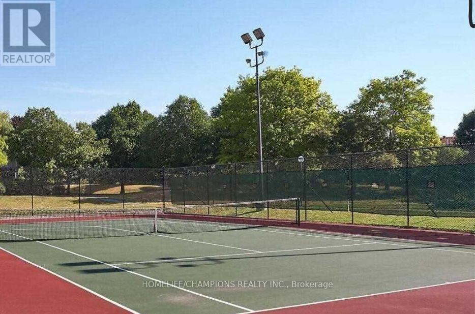 A tennis court with a net and trees in the background.