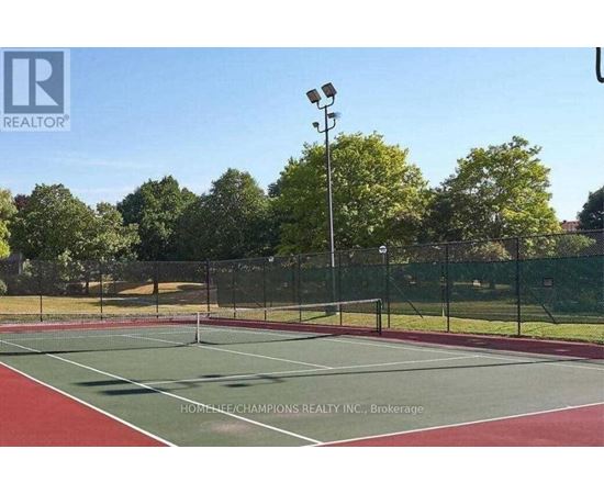A tennis court with a net and trees in the background.