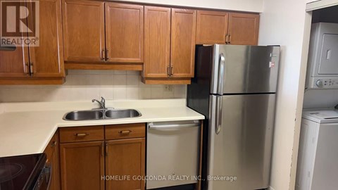 A kitchen with wooden cabinets and a stainless steel refrigerator.