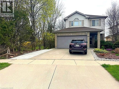 A house with a garage and a car parked in front.