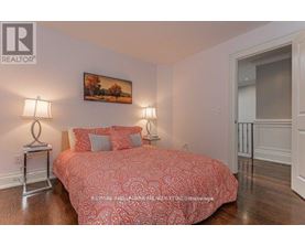 A bedroom with a large bed and a painting on the wall.