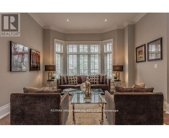 A living room with a glass coffee table and a sofa.