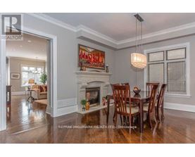 A dining room with a fireplace and a painting above it.