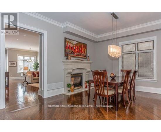 A dining room with a fireplace and a painting above it.