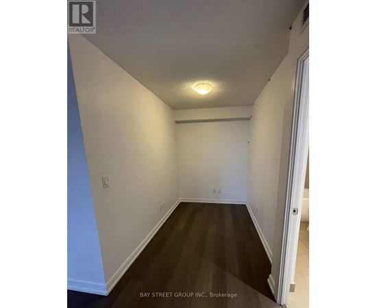 A hallway with a light on the ceiling and a door on the right.