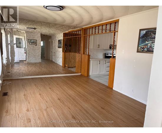 A room with wooden floors and a wall with a picture frame on it.