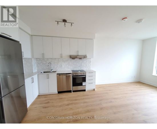 A kitchen with white cabinets and a stainless steel refrigerator.