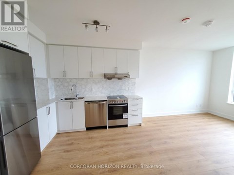A kitchen with white cabinets and a stainless steel refrigerator.