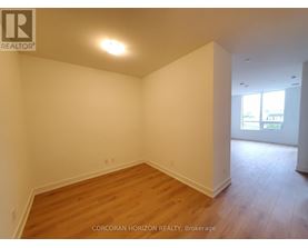 A room with wooden flooring and white walls.