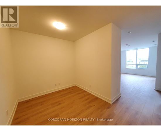 A room with wooden flooring and white walls.