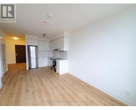 A large, empty room with wooden floors and white walls.