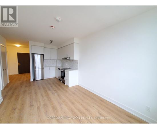 A large, empty room with wooden floors and white walls.
